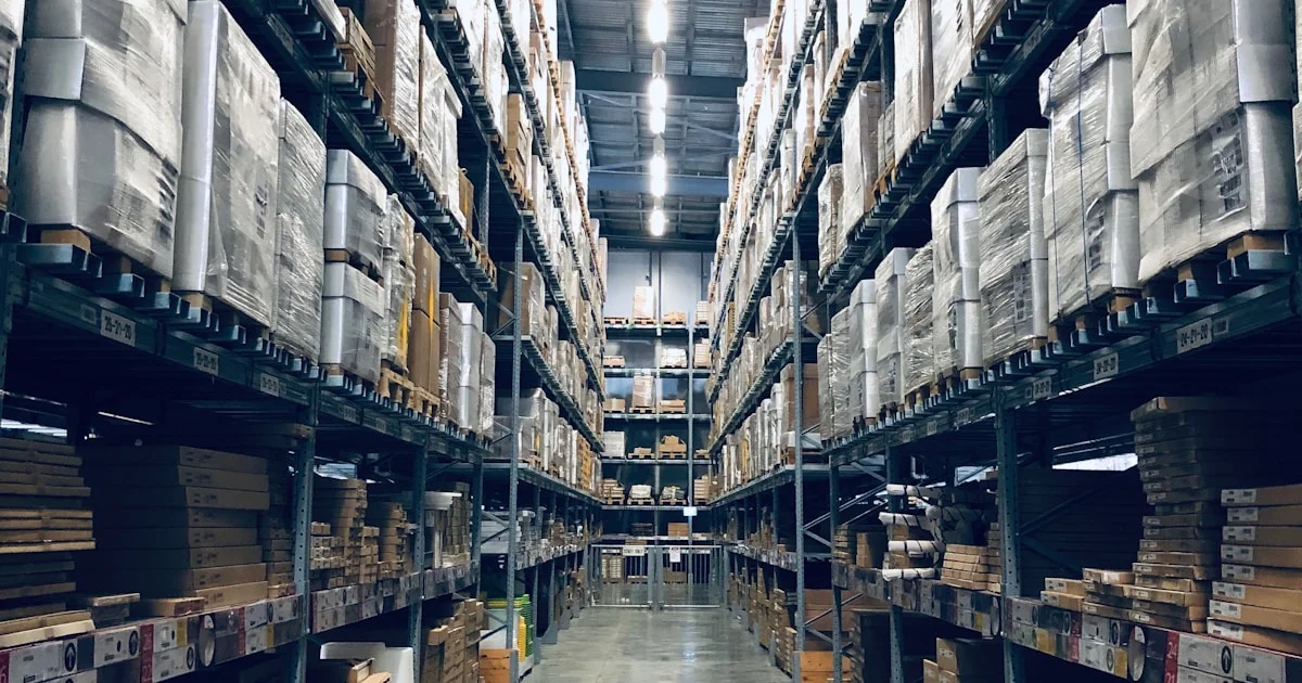 Rows of wholesale products on display at a Dubai wholesale market with boxes stacked on shelves